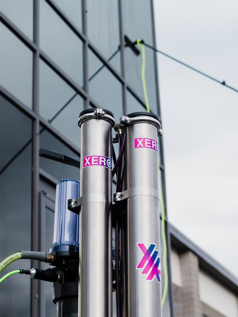 XERO Triple Pure in front of a tall commercial building that is having the windows cleaned