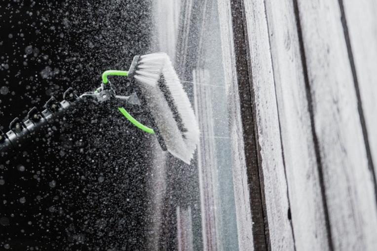 XERO Hybrid Brush spraying a window for cleaning